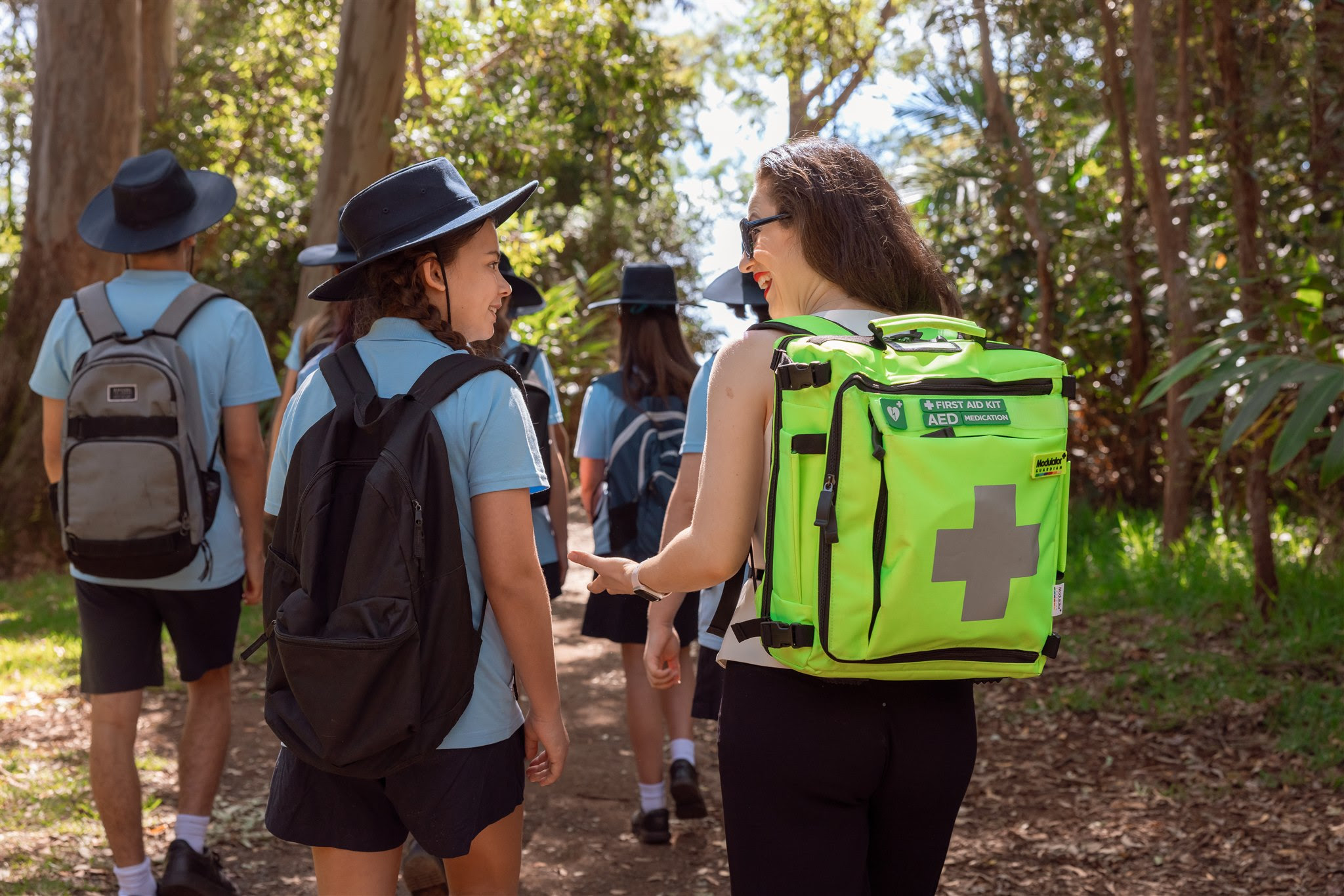 woman walking with student wearing guardian backpack